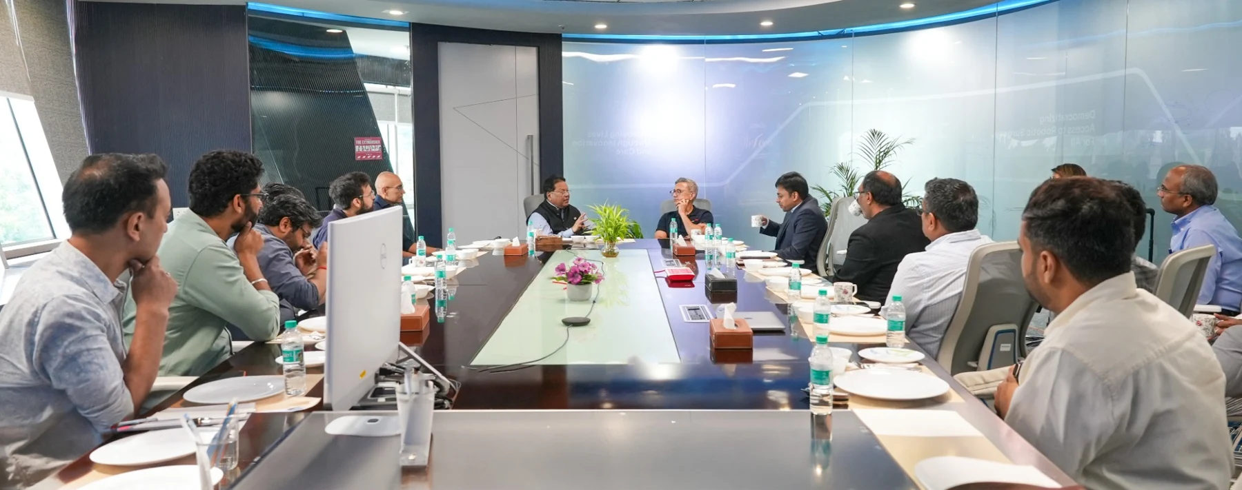 Participants in a meeting around a long conference table