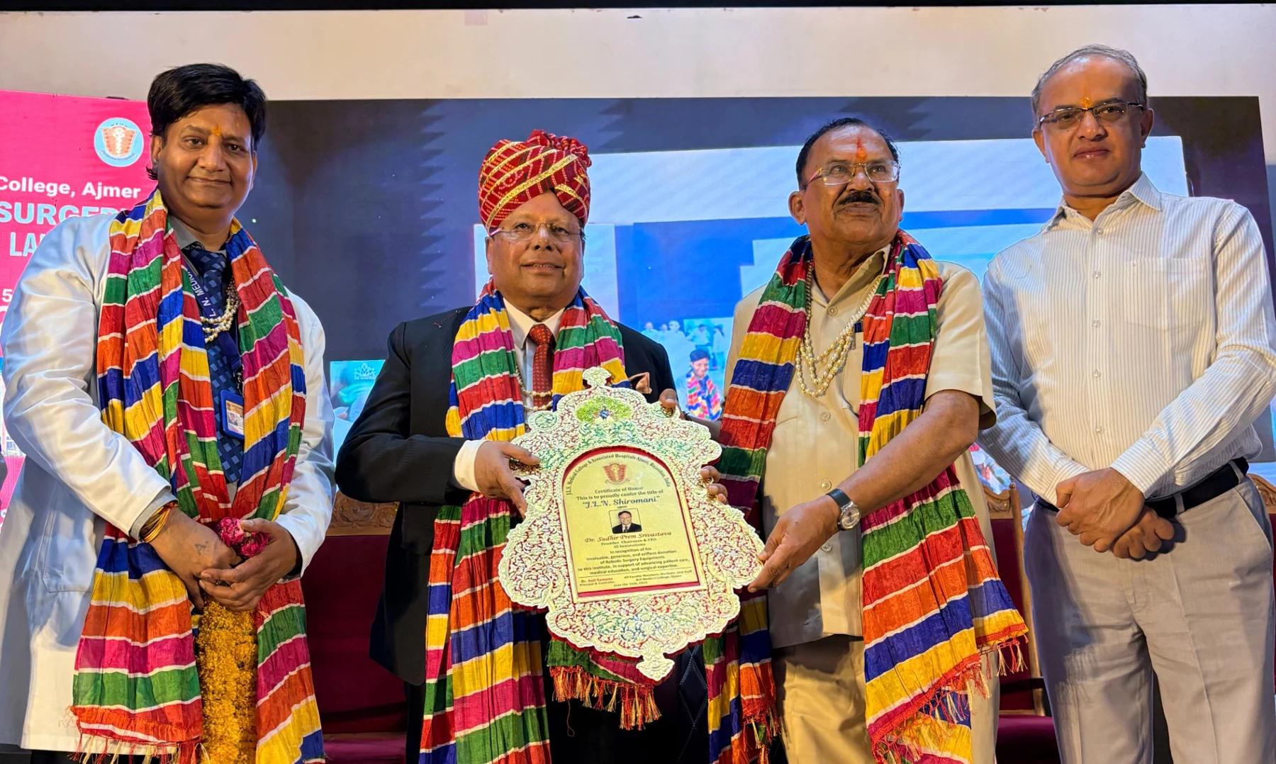 Four participants standing together while holding a commemorative presentation